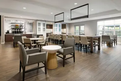 a dining room with tables and chairs and windows at Residence Inn by Marriott King of Prussia in King of Prussia