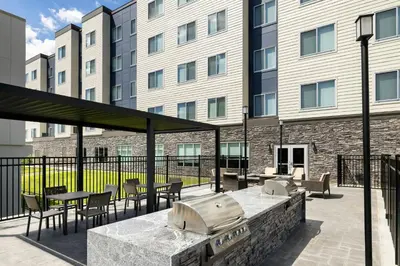a patio with tables and chairs in front of a building at Residence Inn by Marriott King of Prussia in King of Prussia