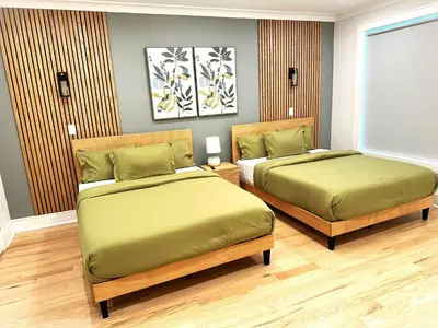 a bedroom with two beds with green sheets at Huge 2000 sqft Luxury & Stylish Condo minutes to New York in Jersey City