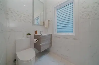 a white bathroom with a toilet and a sink at Huge 2000 sqft Luxury & Stylish Condo minutes to New York in Jersey City