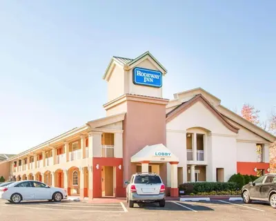 a hotel with cars parked in a parking lot at Rodeway Inn Mount Laurel Hwy 73 in Ramblewood