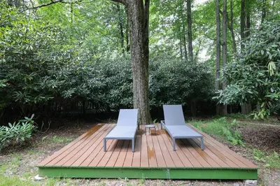 two chairs and a table on a wooden deck at Green Acres Nature Escape in Long Pond