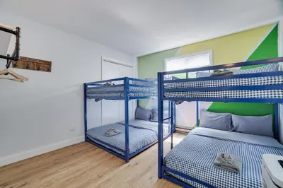 two bunk beds in a room with a green wall at Green Acres Nature Escape in Long Pond
