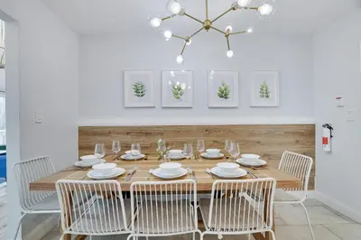 a dining room table with chairs and a chandelier at Green Acres Nature Escape in Long Pond