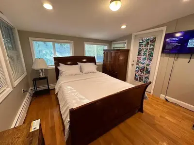 a bedroom with a large bed and a television at Stunning 4BR home close to NYC in Teaneck