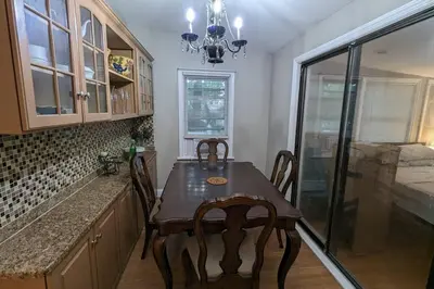 a kitchen with a wooden table and a dining room at Stunning 4BR home close to NYC in Teaneck