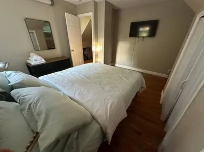 a bedroom with two beds and a mirror at Stunning 4BR home close to NYC in Teaneck