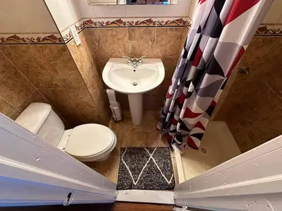 a small bathroom with a toilet and a sink at Stunning 4BR home close to NYC in Teaneck