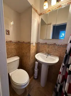a bathroom with a toilet and a sink at Stunning 4BR home close to NYC in Teaneck