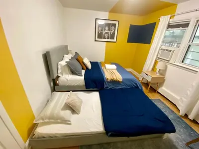 a bedroom with a bed with blue and white sheets at Live in NYC -20 Mins to Rockefeller, MoMA & World in Jersey City