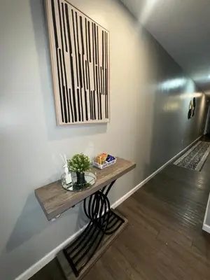 a small table on a wall with a picture at Elegant Apt by EWR & PennStation in Newark