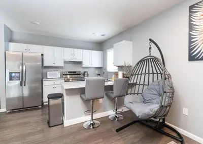 a kitchen with a swing chair in a kitchen at Elegant Apt by EWR & PennStation in Newark