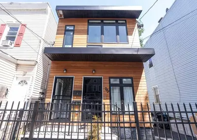 a house with a fence in front of it at Elegant Apt by EWR & PennStation in Newark