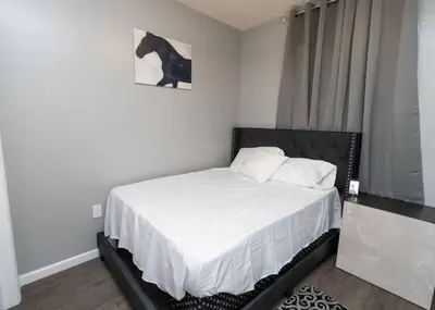 a bedroom with a bed with a horse picture on the wall at Elegant Apt by EWR & PennStation in Newark