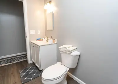 a bathroom with a white toilet and a sink at Elegant Apt by EWR & PennStation in Newark