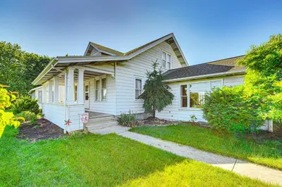 a white house with a porch and a yard at 5 Mi to Hersheypark Family Home with Game Room in Annville