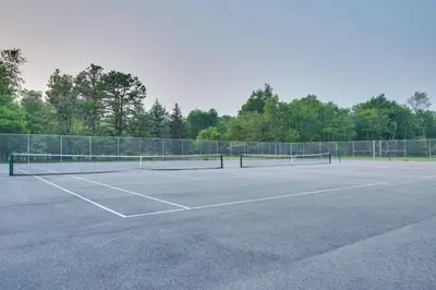 a tennis court with two tennis rackets on it at Spacious Family Retreat Pocono Home with Deck in Albrightsville