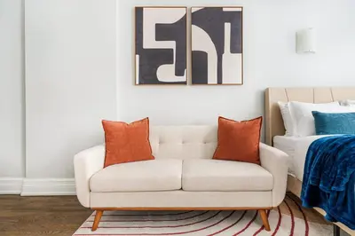 a living room with a white couch with orange pillows at 73-703 New Studio UWS Doorman Gym in New York