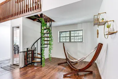 a living room with a spiral staircase and a hammock at Cozy Wooded Retreat Big Bass Lake Home in Lehigh