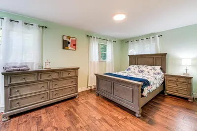 a bedroom with a bed and two dressers at Cozy Wooded Retreat Big Bass Lake Home in Lehigh
