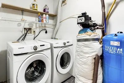 a washing machine and a camera in a laundry room at Cozy Wooded Retreat Big Bass Lake Home in Lehigh