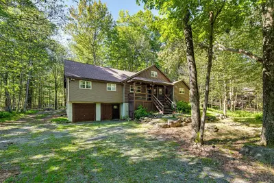 a house in the woods with a yard at Cozy Wooded Retreat Big Bass Lake Home in Lehigh