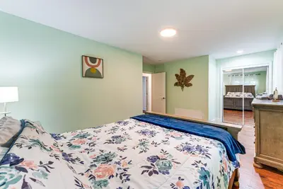 a bedroom with a bed with a floral bedspread at Cozy Wooded Retreat Big Bass Lake Home in Lehigh