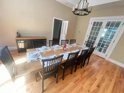 a dining room with a long table and chairs at Beautiful River front home with private pool in Phillipsburg
