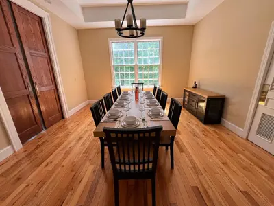 a dining room with a long table and chairs at Beautiful River front home with private pool in Phillipsburg