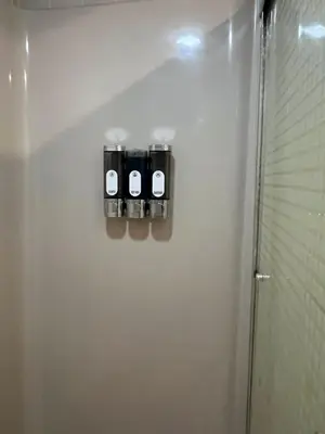 a bathroom with three bottles on the side of a refrigerator at Beautiful River front home with private pool in Phillipsburg