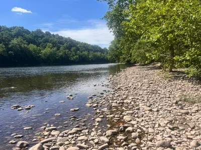 a river with rocks and trees on the side at Beautiful River front home with private pool in Phillipsburg