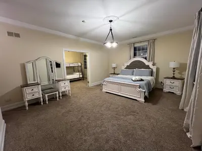 a bedroom with a bed and two dressers and a mirror at Beautiful River front home with private pool in Phillipsburg