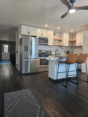 a kitchen with white cabinets and a stainless steel refrigerator at Cozy & Modern 3-Bed Retreat - 8 Mins to Bridge St in Phoenixville