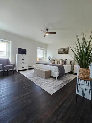 a bedroom with a bed and a couch and a tv at Cozy & Modern 3-Bed Retreat - 8 Mins to Bridge St in Phoenixville