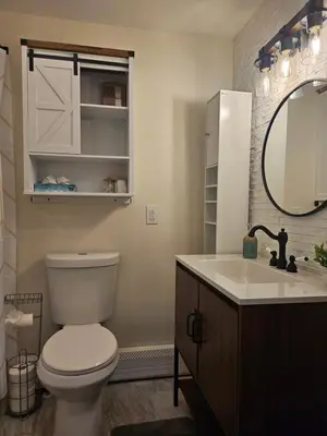 a bathroom with a toilet and a sink and a mirror at Cozy & Modern 3-Bed Retreat - 8 Mins to Bridge St in Phoenixville