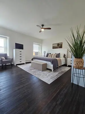 a bedroom with a bed and a couch and a tv at Rustic & Renovated 3 Bed - 8 Min Walk to Bridge St in Phoenixville