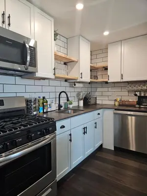 a kitchen with white cabinets and stainless steel appliances at Rustic & Renovated 3 Bed - 8 Min Walk to Bridge St in Phoenixville