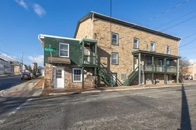an old brick building on the corner of a street at Rustic & Renovated 3 Bed - 8 Min Walk to Bridge St in Phoenixville