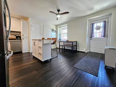 an empty living room with a kitchen and a table at Rustic & Renovated 3 Bed - 8 Min Walk to Bridge St in Phoenixville