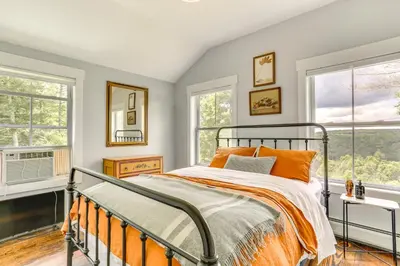 a bedroom with a bed and two windows at Lovely Country Retreat, 4 Mi to Dtwn Narrowsburg! in Narrowsburg