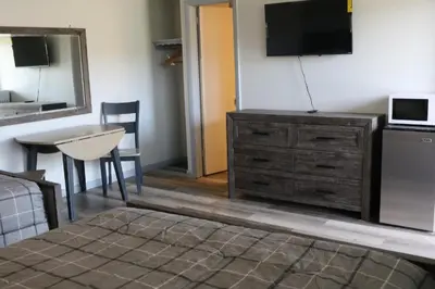 a bedroom with a dresser with a television on a wall at Motel 81 in Dalton
