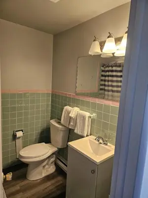 a bathroom with a toilet and a sink and a mirror at Motel 81 in Dalton