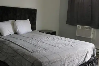 a bedroom with a bed with a white comforter at Motel 81 in Dalton