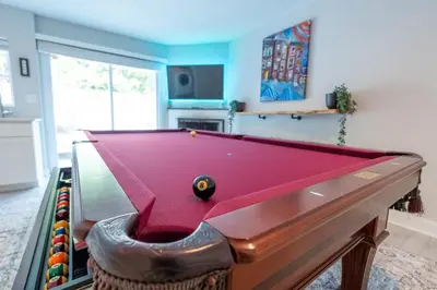 a billiard table in a living room with a pool at Stylish 3BR w Pool Table & Garage in Philadelphia