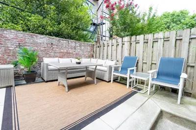 a patio with a table and chairs and a fence at Stylish 3BR w Pool Table & Garage in Philadelphia