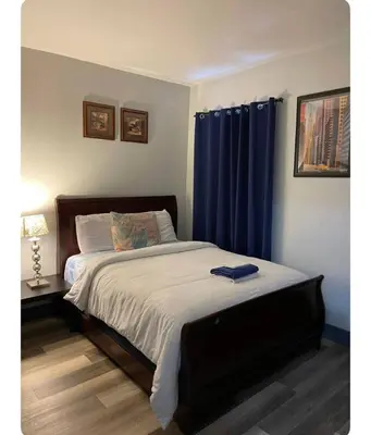 a bedroom with a bed with blue curtains at Cozy Room in Newark