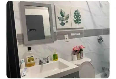 a bathroom with a sink and a mirror and a toilet at Cozy Room in Newark