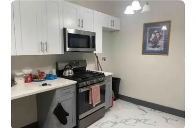 a kitchen with a stove and a microwave at Cozy Room in Newark