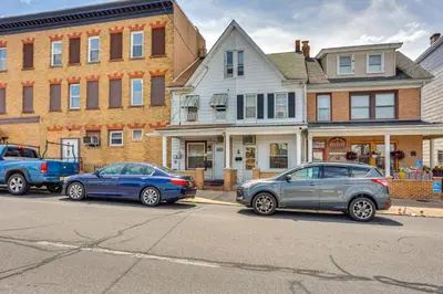 three cars parked on a street in front of houses at Playroom and Fenced Yard Mt Carmel Family Home! in Mount Carmel