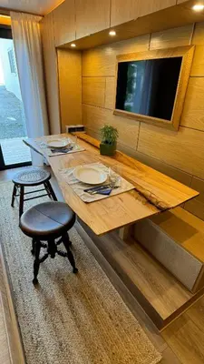 a large wooden table with two chairs and a television at City Hideaway, Off Grid Luxe in Lancaster